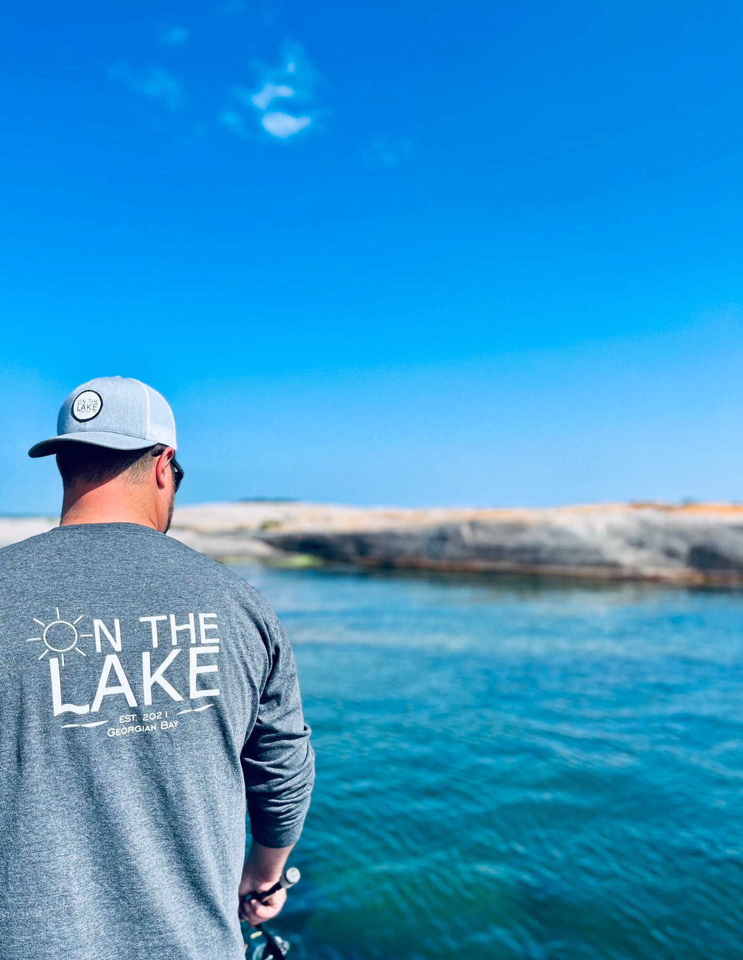 Outdoor apparel for cold weather, Cozy outdoor wear, Cold-weather gear, outdoor clothing, man fishing off a boat with grey long sleeve shirt