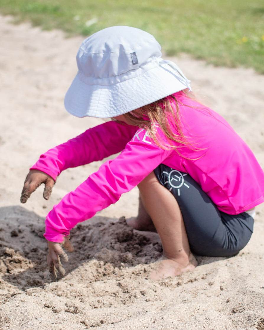 Kids, children UPF 50+ natural sun protection swimwear clothing Canada, UPF 50+ swimwear, Sun protective clothing, UV swimwear, Sun-safe apparel, UV protection for water activities, Sun-blocking swimwear, Family sun protection clothing, Sun safe boating attire, quality children's clothing Canada, little girl playing in the sand with UPF 50+ sun protection clothing